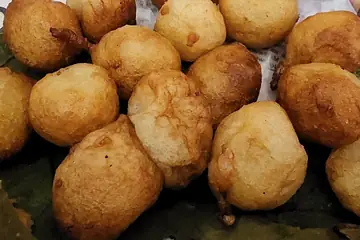 A heap of golden fried punugulu on a leaf