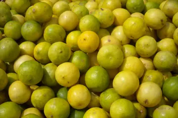 A heap of round yellow and green limes