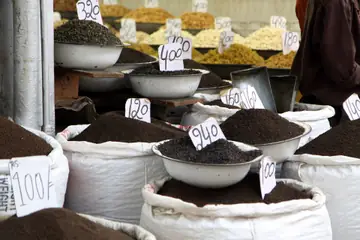 Bowls and sacks of loose tea leaves with handwritten paper price tags.