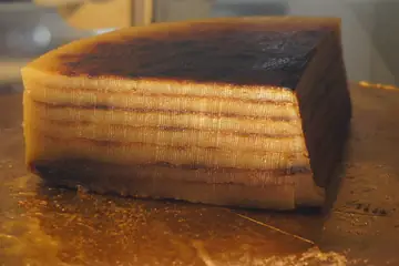 A thick slice of layered bebinca cake with a dark, browned top
