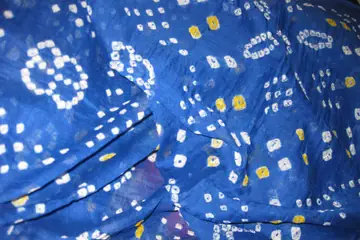 A blue bandhani dupatta with small white tie-dyed dots and rings