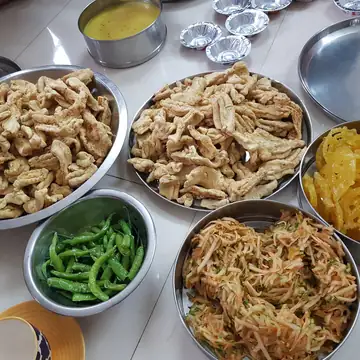 Steel ki thaali mein gathiya, jalebi, hari mirch aur kasi hui gajar ke sambharo ki steel ki katoriyan