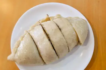 A steamed stuffed siddu bread cut in slices on a white plate