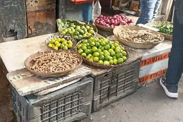 जमशेदपुर के बाज़ार के ठेले पर नींबू, कच्ची मूँगफली, प्याज़ और अदरक की टोकरियाँ, नीचे क्रेट