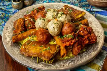 A platter of meatballs, ribs and kebabs served on an engraved metal plate