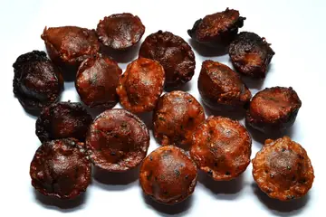 A heap of dark brown unniyappam, a Kerala sweet fried in a pan