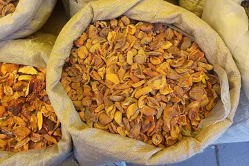 लेह के बाज़ार में किनारे तक भरे, खुले बोरों में सूखी ख़ुबानी की फाँकें