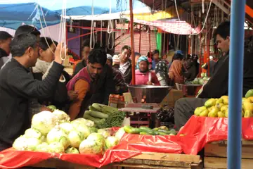 लेह के बाज़ार में सब्ज़ी का ठेला, लाल कपड़े पर फूलगोभी की ढेरी और ऊपर लटका तराज़ू का पलड़ा
