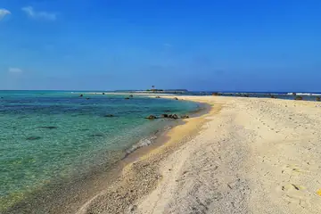 Clear green lagoon water and a long pale sand spit on Kalpeni.