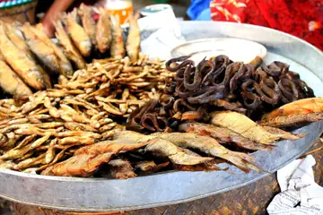 A large round tray of assorted dried fish laid out for sale at Ima Keithel in Imphal