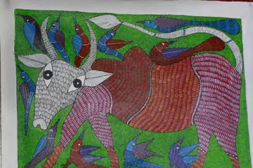 A Gond painting of a red patterned bull with blue birds on a green background