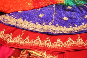 Stacked red, blue and orange Rajasthani skirts with gold embroidery on sale in Nawalgarh