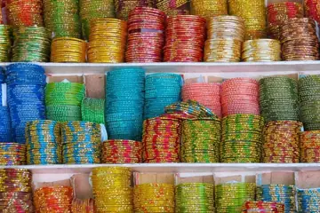 Shelves of glittering green, blue, pink, red and gold bangles stacked in rows in Laad Bazaar, Hyderabad