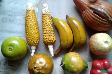 Hand-painted wooden toy fruits and vegetables: corn, bananas, mangoes, apples and a red pepper