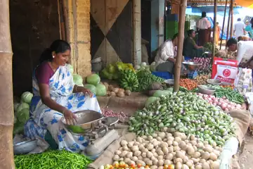 வெளியே உட்கார்ந்து, கையில் இருக்கும் போனைக் குனிந்து பார்க்கும் டெனிம் சட்டை அணிந்த ஒருவர்