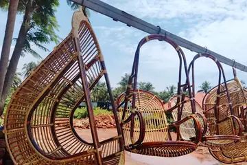 রাস্তার পাশে তালগাছের নিচে একটা দণ্ড থেকে সারি দিয়ে ঝুলছে বেতের দোলনা চেয়ার