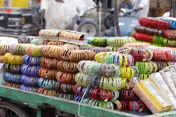 Heaps of glass bangles in red, blue, green and yellow piled on a cart in Jaipur