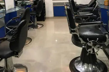 Black barber-style styling chairs and mirrors in a clean beauty parlour