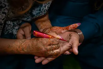 Henna being drawn on a hand with a cone