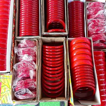 Red glass bangles stacked in open boxes for sale