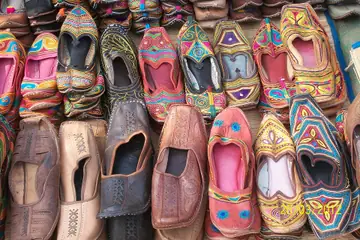 A heap of colourful embroidered juttis stacked at a shoe stall in Calangut, Goa