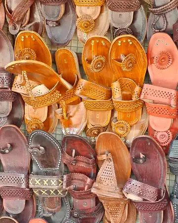Tan and brown Kolhapuri leather chappals piled up close to the camera