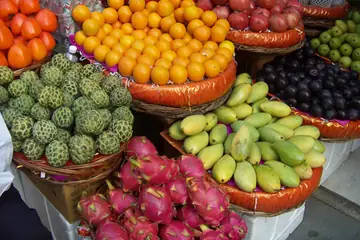 Baskets of oranges, custard apples, dragon fruit, mangoes and pomegranates at a fruit shop