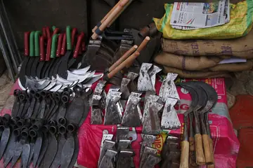 Axes, sickles, hoes and garden knives laid out at a hardware stall