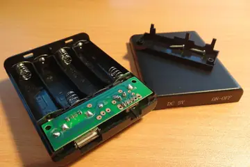 A power bank opened to show its battery holder and circuit board