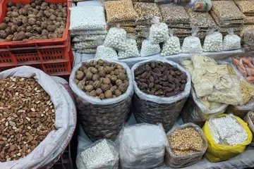 Open sacks and packets of nuts, seeds and dried goods piled on a market stall