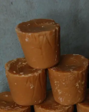 Golden jaggery blocks stacked in a pile
