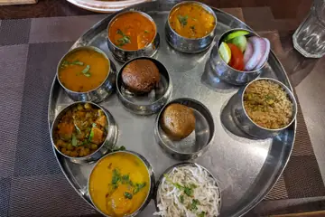 राजस्थानच्या जयपूरमध्ये स्टीलच्या ताटात आमट्या, बाटी आणि भाताच्या वाट्या असलेली राजस्थानी थाळी