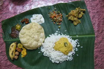 केळीच्या पानावर भात, सांबार, पापड आणि तोंडीलावण्यांसह शाकाहारी सद्य जेवण