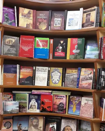 A tall curved bookshelf full of books with their covers facing out
