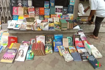 പശ്ചിമ ബംഗാളിലെ കൊൽക്കത്തയിൽ നടപ്പാതയിൽ പഴയ പുസ്തകങ്ങളുടെ നിരകൾ ഒരുക്കുന്ന ഒരു പുസ്തക വ്യാപാരി
