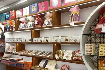 Wooden shelves of boxed and ribbon-wrapped sweets in a sweet shop