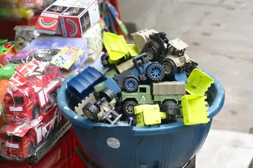 A blue tub of toy trucks and diggers at a toy stall
