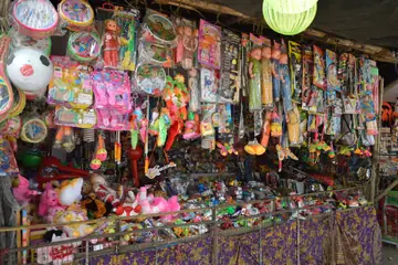 A toy stall front in Kolkata crowded with dolls, balls and toys hanging in rows